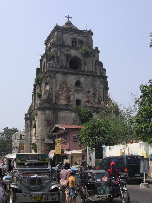 Old church tower beside busy street
